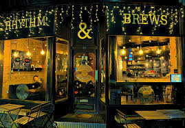 Rhythm & Brews venue interior showcasing stage area with musical instruments and bar with craft beer taps